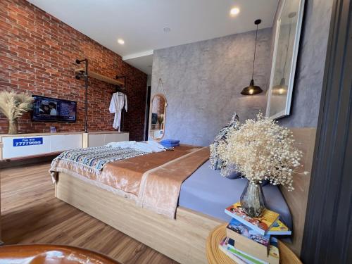 a bedroom with a bed and a brick wall at MIS HOSTEL Cần Thơ in Can Tho