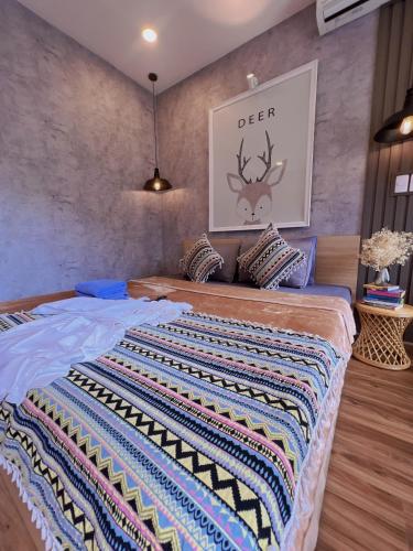a bedroom with a large bed with a blanket on it at MIS HOSTEL Cần Thơ in Can Tho