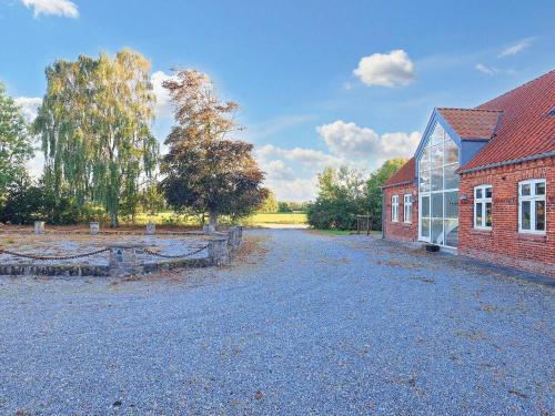 a barn and a building with a gravel driveway at 20 person holiday home in Sæby-By Traum in Sæby