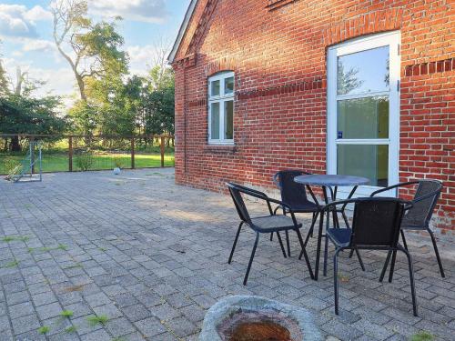 a patio with a table and chairs next to a brick building at 20 person holiday home in Sæby-By Traum in Sæby