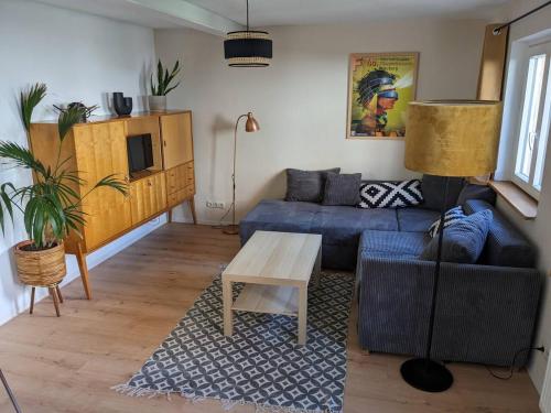 ein Wohnzimmer mit einem blauen Sofa und einem Tisch in der Unterkunft Wohnen am Main 1a-ammain in Margetshöchheim