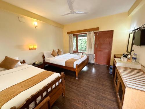 a hotel room with two beds and a television at Lake View Resort in Pokhara