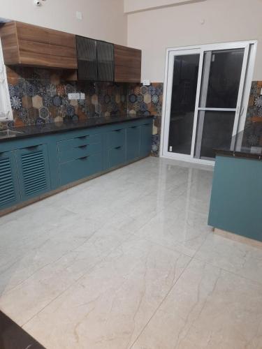 a kitchen with blue cabinets and a tile floor at Swayamkrushi 3rd Floor in Hyderabad