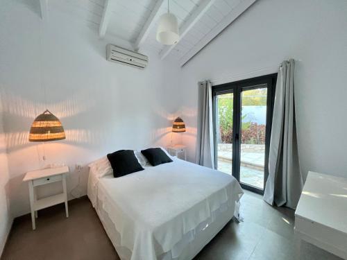 een witte slaapkamer met een bed en een raam bij Peaceful 2 BR Villa NR Gaios w Seaview and Pool in Gaios