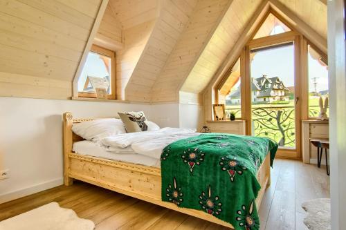 a bedroom with a bed in a room with windows at Domek Rogata Chata Deluxe, Kościelisko in Kościelisko