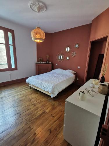 een slaapkamer met een bed en een tafel. bij Charmant appartement proche de la gare in Vichy