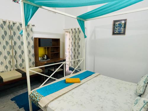 1 dormitorio con litera y dosel azul en Atithya en Udaipur