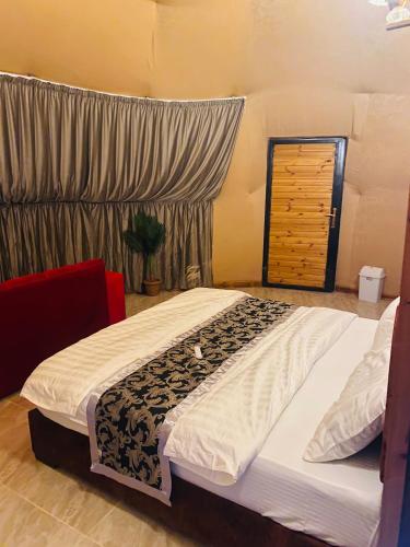 a bedroom with a large bed in a room at Sandy Camp Wadi Rum in Wadi Rum