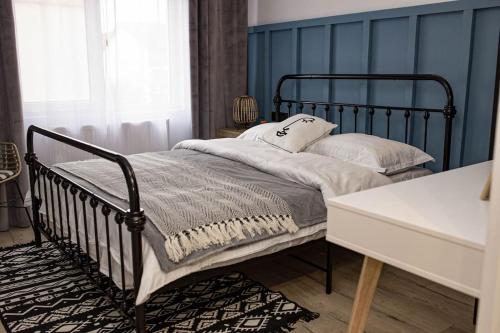 um quarto com uma cama preta e uma secretária branca em blue moon. cozy apartment near Iulius Mall em Cluj-Napoca