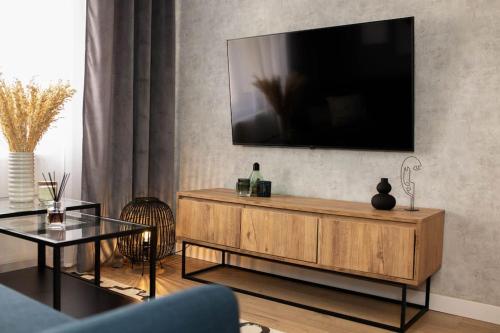 uma sala de estar com uma televisão de ecrã plano na parede em blue moon. cozy apartment near Iulius Mall em Cluj-Napoca