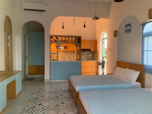 Santorini Villa Cam Ranh في كام رنه: غرفة نوم بسريرين ومطبخ