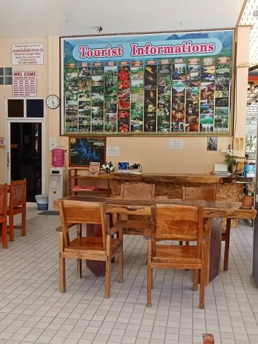 un restaurant avec des tables et des bancs en bois dans un magasin dans l'établissement Khao Sok Inn Hostel, à Khao Sok