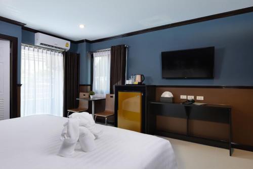 a hotel room with a bed and a flat screen tv at The Breton Hotel Media in Bangkok