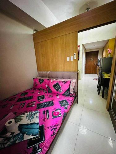 um quarto com uma cama rosa num quarto em SHELL RESIDENCE em Manila