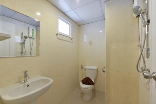 uma casa de banho com um lavatório, um WC e um chuveiro em The Breton Hotel Media em Bangkok