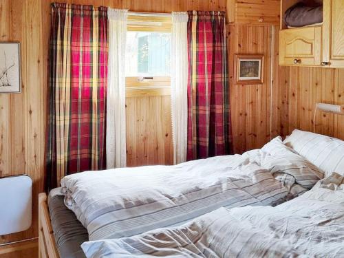 Bett in einem Zimmer mit Fenster in der Unterkunft Holiday home Bratland 