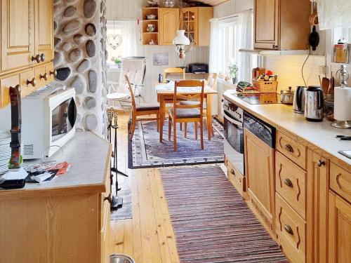 eine Küche mit Holzschränken sowie einem Tisch und Stühlen in der Unterkunft Holiday home Bratland 
