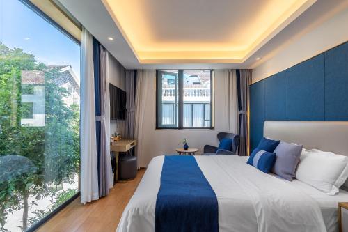ein Hotelzimmer mit einem Bett und einem großen Fenster in der Unterkunft Hangzhou Ziwei Boutique Homestay in Hangzhou