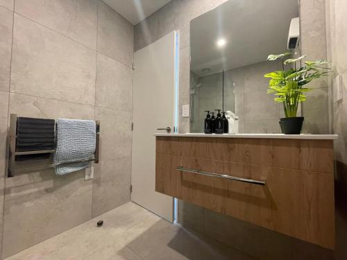 a bathroom with a sink and a mirror at Inner City Luxury With Free Parking in Christchurch