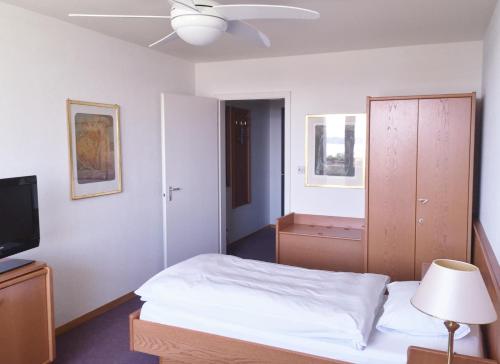 a bedroom with a bed and a ceiling fan at Fontana Budget in Twann