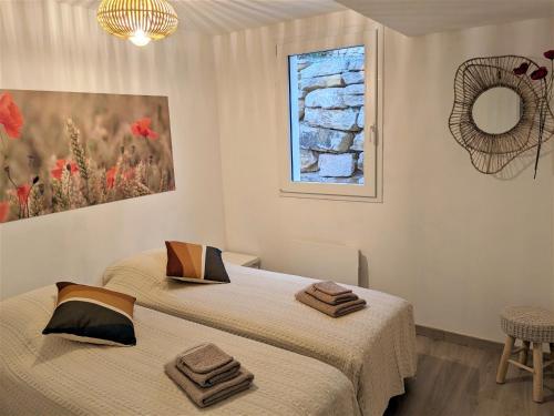two beds in a white room with a mirror at Les pierres dorées in Saint-Maurice-sur-Eygues