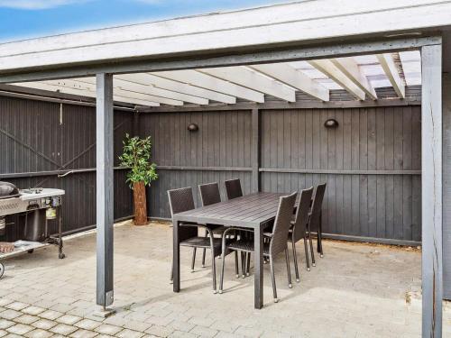 a wooden table and chairs on a patio at 6 person holiday home in F rvang in Fårvang