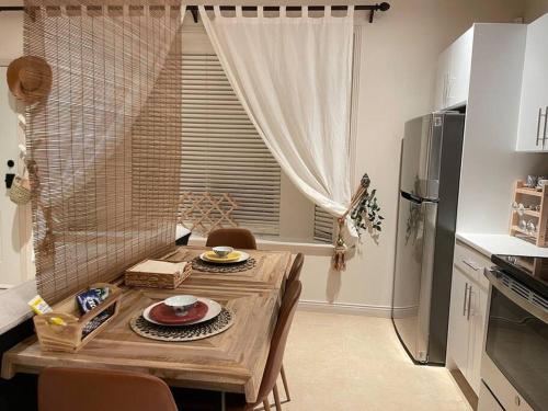 バーナビーにあるMetrotown Exquisite 1 Bed Room Private Entire Suite with Separated Entranceのキッチン(木製テーブル、椅子、冷蔵庫付)