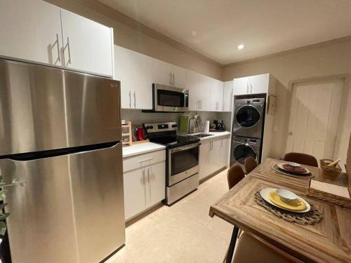 a kitchen with white cabinets and a stainless steel refrigerator at Metrotown Exquisite 1 Bed Room Private Entire Suite with Separated Entrance in Burnaby
