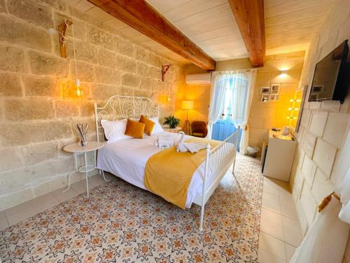 a bedroom with a bed and a table in a room at Ta' Ġilarda Boutique Living in Birbuba