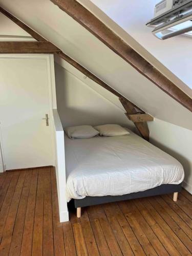 a small bed in a room with a attic at Studio moderne en centre ville in Guipel