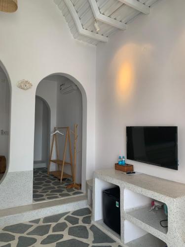 a living room with a flat screen tv on a wall at Santorini Villa Cam Ranh in Cam Ranh