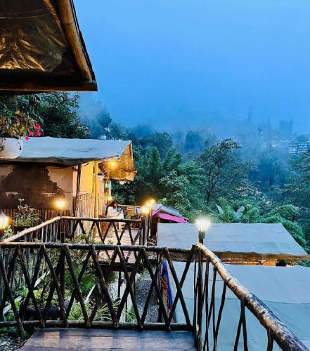 un resort con balcone con vista sulla città di Deoja Forest Stay a Darjeeling
