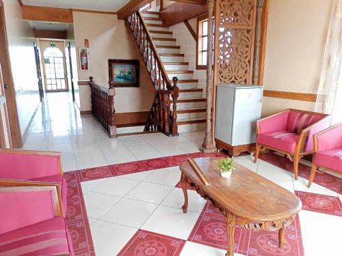 sala de estar con sillas rosas y mesa en Regular Room in Casa de Piedra Pension House 