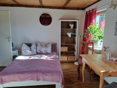 una camera con letto e tavolo in legno di Martha a Langenchursdorf