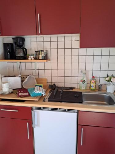 a kitchen with red cabinets and a sink at Martha in Langenchursdorf