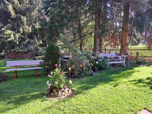 a garden with a park bench and some flowers at Martha in Langenchursdorf