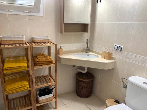 a bathroom with a sink and a toilet and towels at Holiday Home Benidorm with sea views, roof terrace and swimming pool in Benidorm