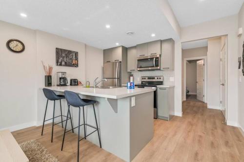 a kitchen with a counter and two bar stools at Brand New Executive Suite in Calgary