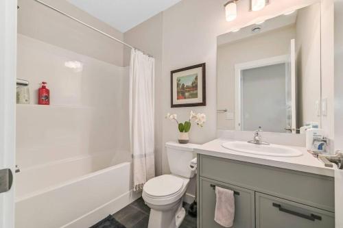 a bathroom with a sink and a toilet and a tub at Brand New Executive Suite in Calgary