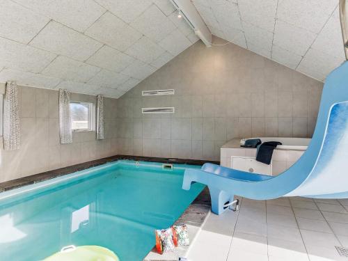 a swimming pool with a slide in a bathroom at 14 person holiday home in Idestrup in Marielyst