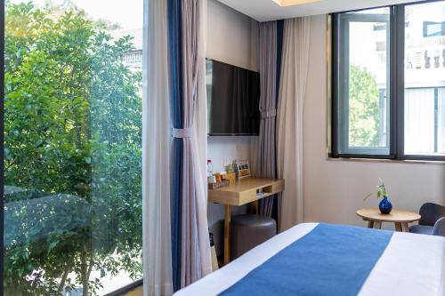 a hotel room with a bed and a large window at Hangzhou Ziwei Boutique Homestay in Hangzhou