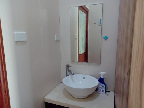 a bathroom with a white sink and a mirror at Apartment in Port Moresby - Short Stays in Port Moresby