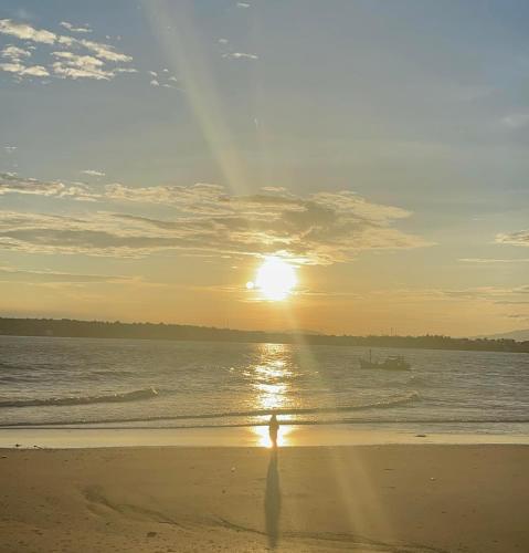 a person walking on the beach at sunset at Villa sân vườn Misa in Phan Thiet