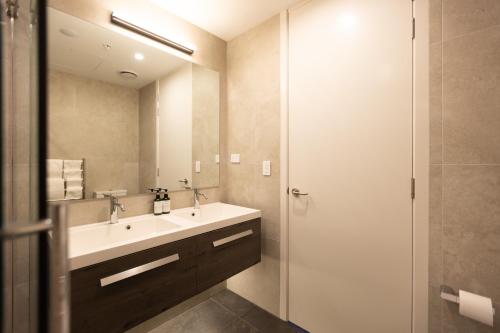 a bathroom with a sink and a shower at Luxury 2 Bedroom CBD Apartment with Free Parking in Christchurch