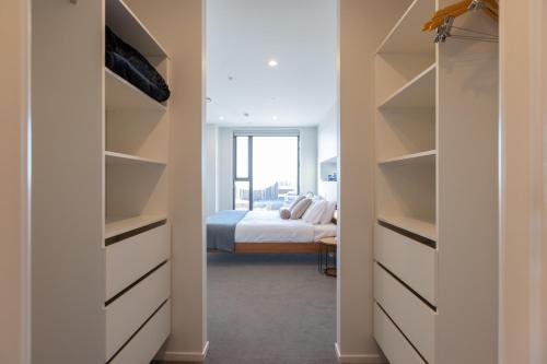 a walk in closet with a bed in a bedroom at Luxury 2 Bedroom CBD Apartment with Free Parking in Christchurch