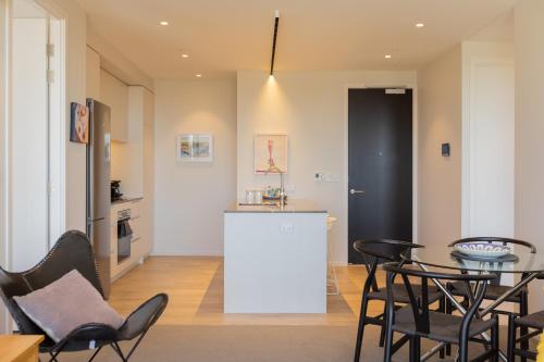 a kitchen and dining room with a table and chairs at Luxury 2 Bedroom CBD Apartment with Free Parking in Christchurch