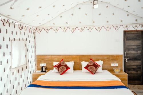 a bedroom with a bed with red pillows at Desert Safari Camp & Resort Sam in Sām