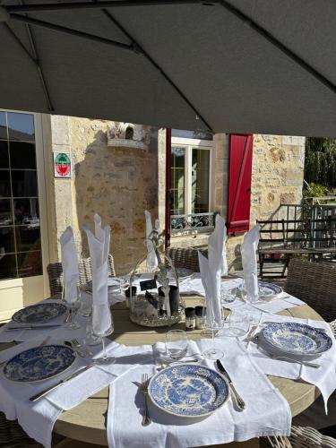 stół z niebiesko-białymi talerzami i przyborami kuchennymi w obiekcie Moulin Le Fleurie w mieście Charenton-du-Cher