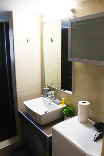 a bathroom with a sink and a mirror at AIOLOS VOULA near the sea apartment in Athens
