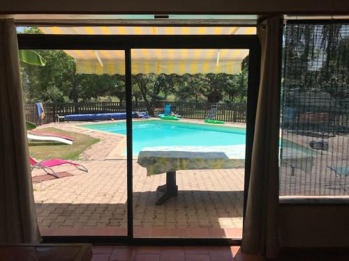 a view of a swimming pool from a window at Gite de charme en pierres apparentes : Les Granges in Gardonne
